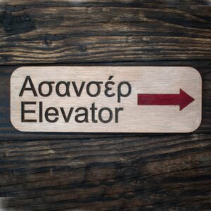 ξύλινη πινακίδα μακρόστενη 18Χ6cm me tiw l;ejeiw "ασανσέρ" και "elevator" χαραγμένες και ένα κόκκινο βέλος προς τα δεξιά