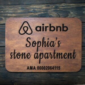 ξυλινη πινακιδα airbnb καρυδι πανω σε ξυλινη επιφανεια