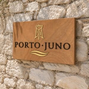 Αρχική 11 Πινακίδα ξενοδοχείου Porto Juno από ξύλο με χρυσές και μαύρες ακρυλικές λεπτομέρειες σε εξωτερικό πέτρινο τοίχο - Ξύλινη Επιγραφή με Λογότυπο από Plexiglass